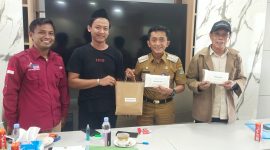 Sikin [menggunakan peci hitam] menerima hadiah dari pejabat setempat atas ide 