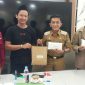 Sikin [menggunakan peci hitam] menerima hadiah dari pejabat setempat atas ide 
