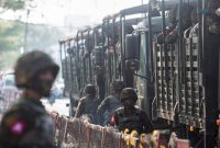 Tentara yang berbaris saat masyarakat berkumpul untuk protes kudeta militer, di Yangon, Myanmar (15/2/2021) | Foto: REUTERS