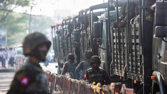 Tentara yang berbaris saat masyarakat berkumpul untuk protes kudeta militer, di Yangon, Myanmar (15/2/2021) | Foto: REUTERS