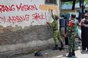 Petugas sedang menghapus corat-coret 'Orang Miskin Dilarang Sakit' di Solo (2021) | Foto: Detikcom / Ari Purnomo