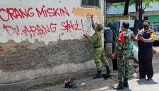 Petugas sedang menghapus corat-coret 'Orang Miskin Dilarang Sakit' di Solo (2021) | Foto: Detikcom / Ari Purnomo