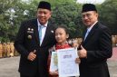 Wali Kota Bekasi Tri Adhianto (kiri) menyerahkan penghargaan kepada penari cilik Tengku Audy Fattiyaturahma dalam Apel Pagi Gabungan Aparatur di Lapangan Pemkot Bekasi, Senin (12/10) | Foto: Pemkot Bekasi