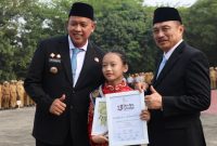 Wali Kota Bekasi Tri Adhianto (kiri) menyerahkan penghargaan kepada penari cilik Tengku Audy Fattiyaturahma dalam Apel Pagi Gabungan Aparatur di Lapangan Pemkot Bekasi, Senin (12/10) | Foto: Pemkot Bekasi