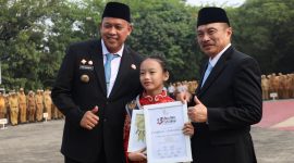 Wali Kota Bekasi Tri Adhianto (kiri) menyerahkan penghargaan kepada penari cilik Tengku Audy Fattiyaturahma dalam Apel Pagi Gabungan Aparatur di Lapangan Pemkot Bekasi, Senin (12/10) | Foto: Pemkot Bekasi