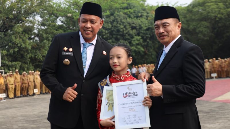 Wali Kota Bekasi Tri Adhianto (kiri) menyerahkan penghargaan kepada penari cilik Tengku Audy Fattiyaturahma dalam Apel Pagi Gabungan Aparatur di Lapangan Pemkot Bekasi, Senin (12/10) | Foto: Pemkot Bekasi