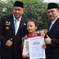 Wali Kota Bekasi Tri Adhianto (kiri) menyerahkan penghargaan kepada penari cilik Tengku Audy Fattiyaturahma dalam Apel Pagi Gabungan Aparatur di Lapangan Pemkot Bekasi, Senin (12/10) | Foto: Pemkot Bekasi